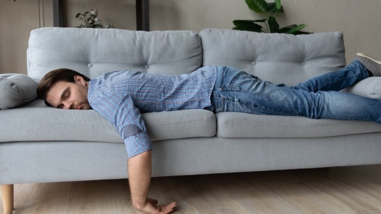 Unmotivated man laying on couch
