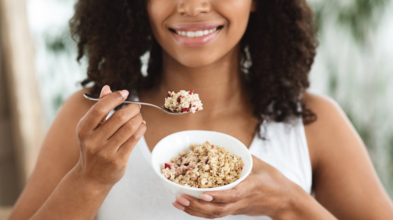 Woman eating oatmeal with fruits