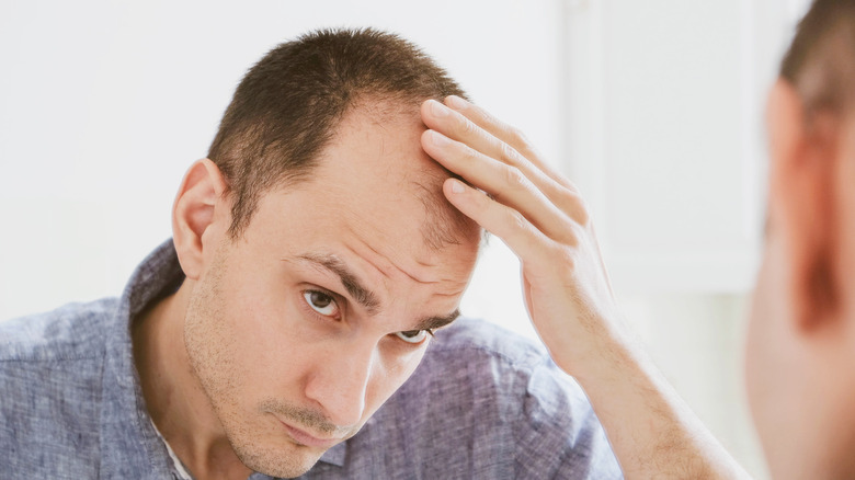 Man looking at thinning hair 