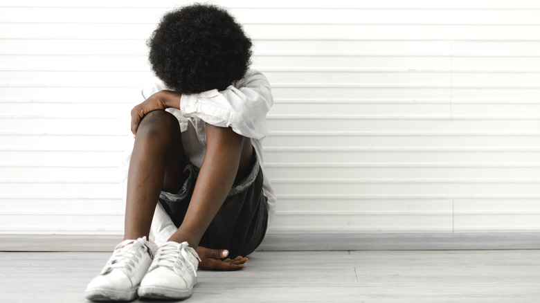 seated boy with head down