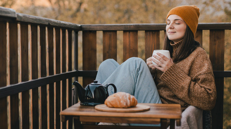 woman savoring her tea and croissant while sitting outside