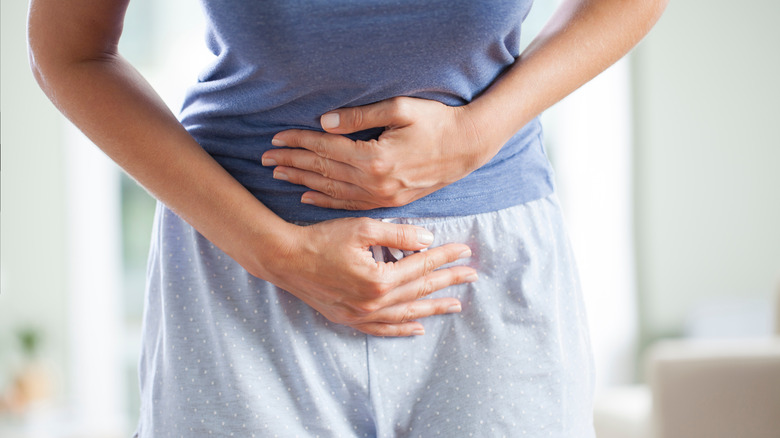 woman holding her stomach in pain