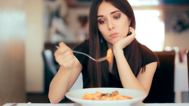 woman looking at her bowl of pasta