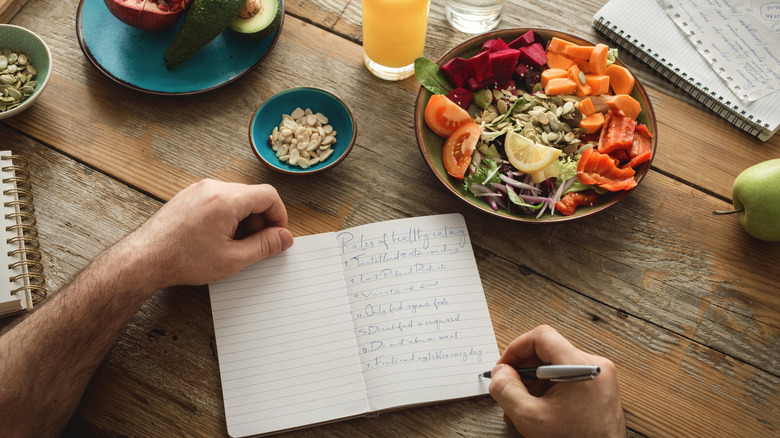 Notebook on table surrounded by food