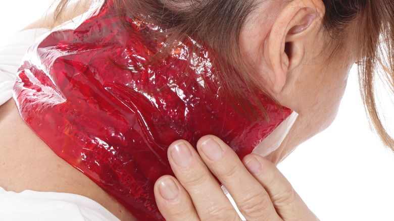 woman using cold compress on neck