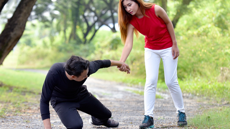 woman helping man up after collapsing