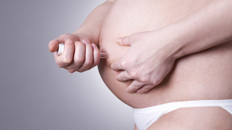 pregnant woman injecting medicine