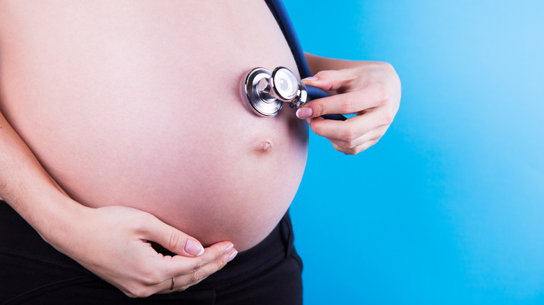 pregnant woman holding heart monitor  
