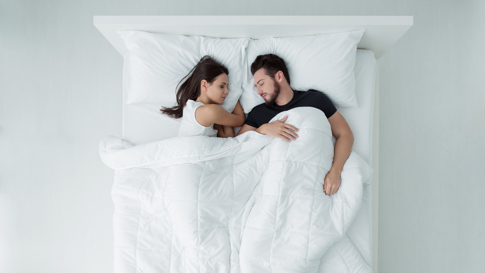 couple sleeping in bed together 