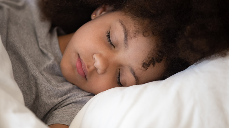 Young child asleep on pillow with eyes closed