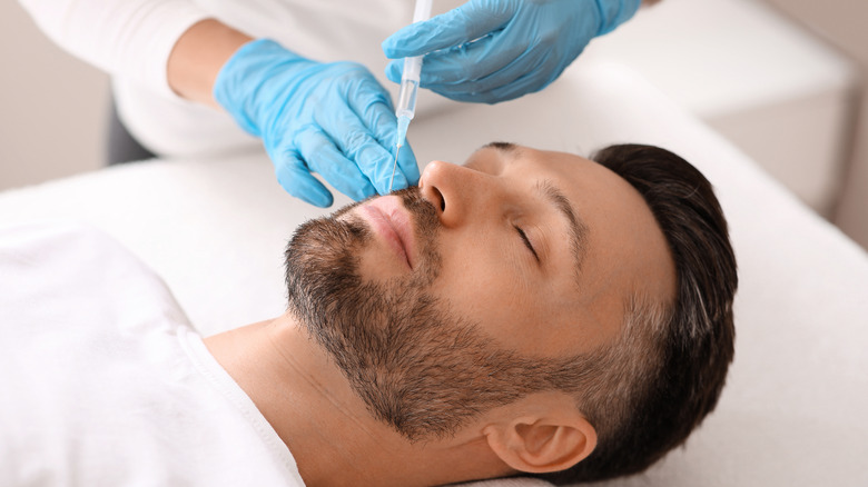 bearded man receiving lip fillers 