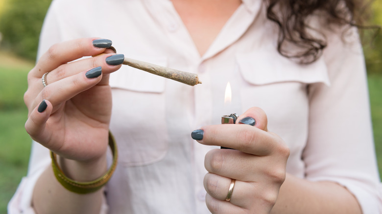 woman lighting a marijuana cigarette