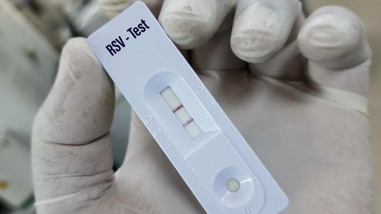 Gloved hand holding RSV test