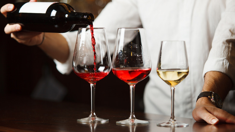 Chef pouring 3 glasses of red and white wine