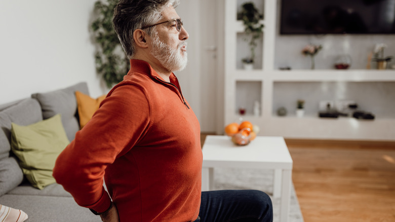 Older man touching lower back in pain