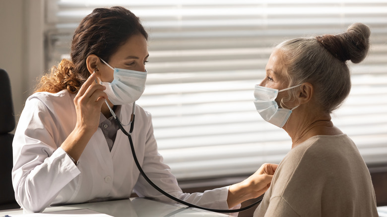 doctor listening to patient's heart with stethoscope