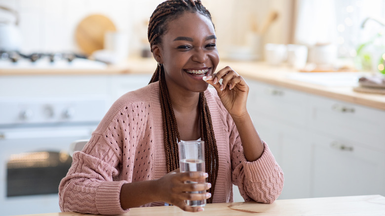 clear-skinned woman smiling holding acne photo