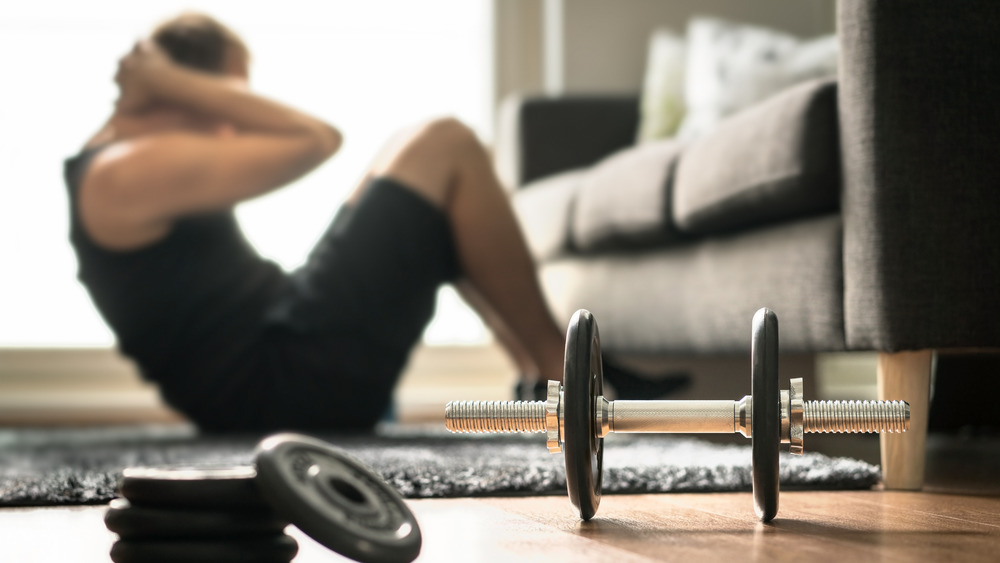 Man doing ab exercises at home with weights 