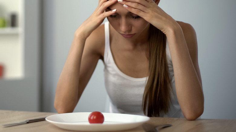 Woman eating small tomato