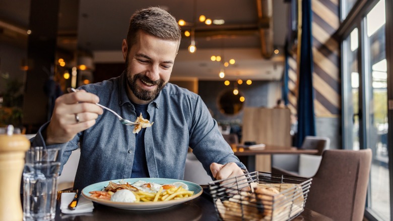 man eating eggs at breakfast