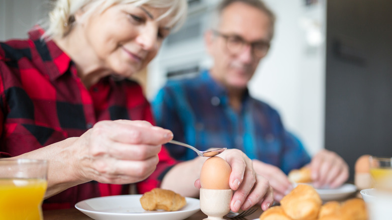 mature couple eating breakfast featuring boiled eggs