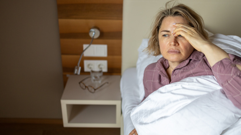 An older woman waking up with a headache