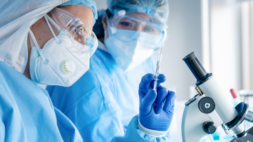 Generic photo of scientists with syringe in research lab