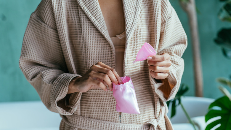 Woman unwrapping a menstrual cup