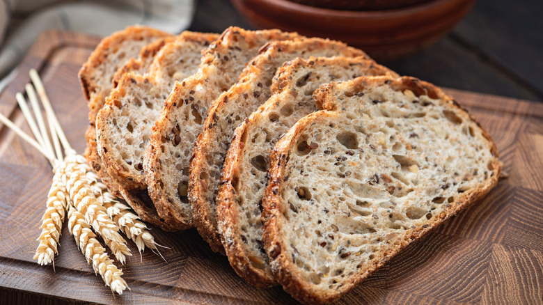 Slices of sourdough wheat bread on a wood cutting board