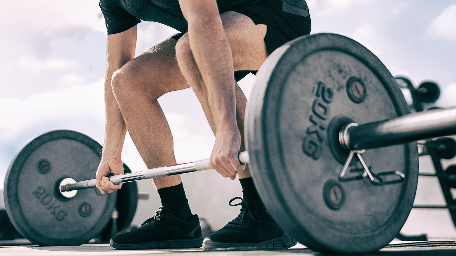 Real weight. Мужчина присел. Heavy Lifting. Lifting on Socks with a Barbell on a Hill.