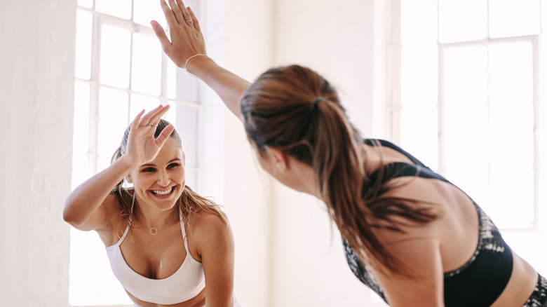 Two women high five after working out