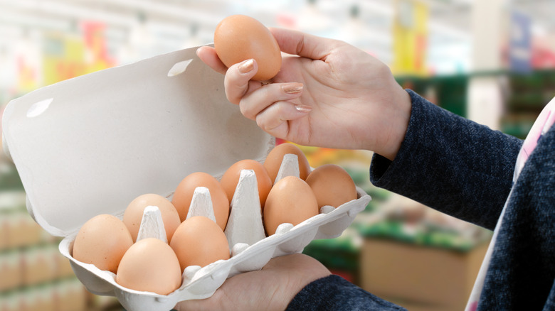 A woman holding one dozen eggs