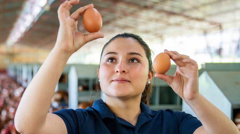 A woman holding two eggs