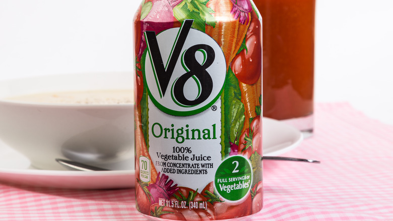 can of v8 juice next to a glass of juice