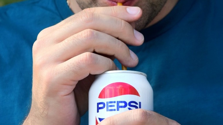 man drinking can of pepsi
