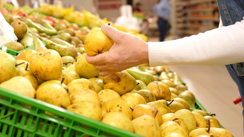 Woman buying pears from a supermarket