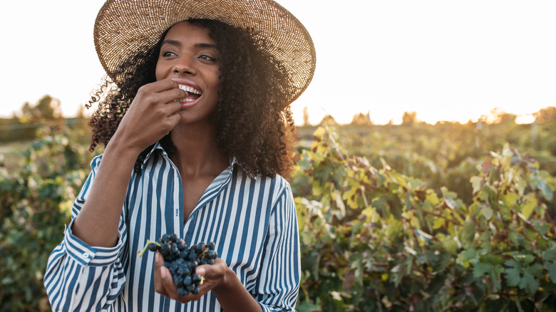 Healthy, young woman eating grapes 