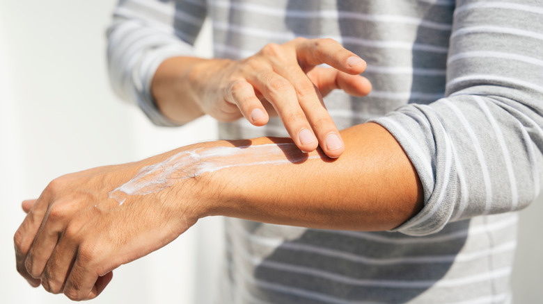 Person applying sunscreen on arm