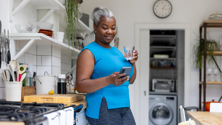 woman tracking her water intake on her phone