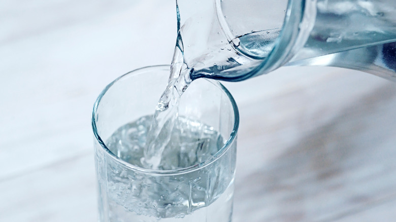 Water being poured from pitcher into cup