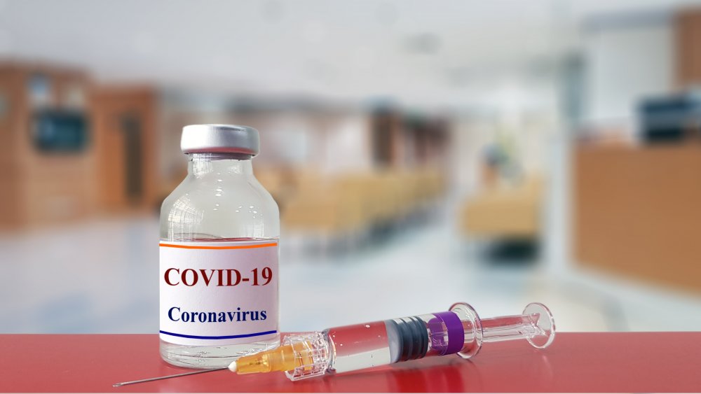 Vaccine bottle with words COVID-19 Coronavirus, and needle