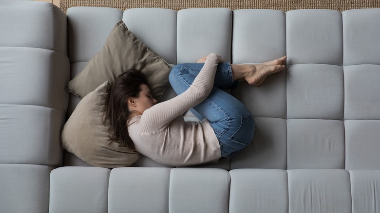 woman curled up on couch suffering depression