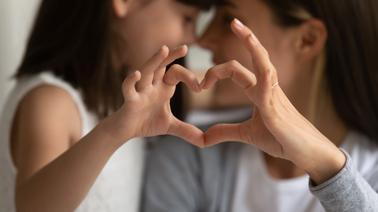 mother and daughter heart hands