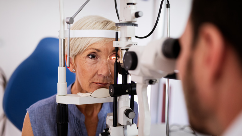Woman resting chin in eye-exam machine