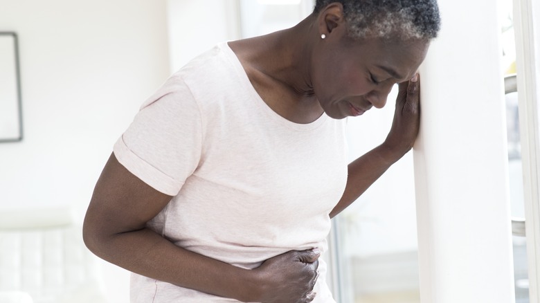 woman leaning over in stomach discomfort