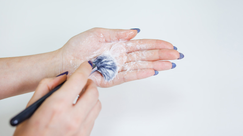 Women's hands washing makeup brushes 