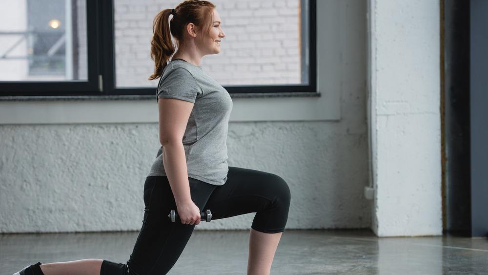 Woman doing lunges with dumbbells 