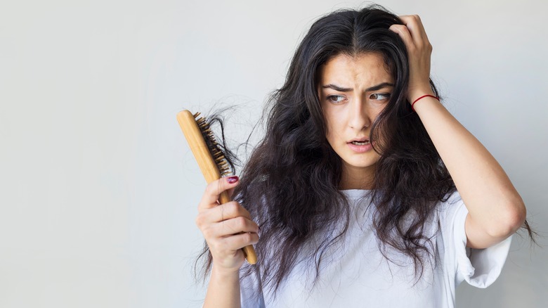 Woman with brush whose hair is coming out