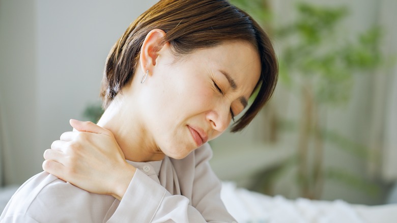 Woman grimacing because of shoulder pain