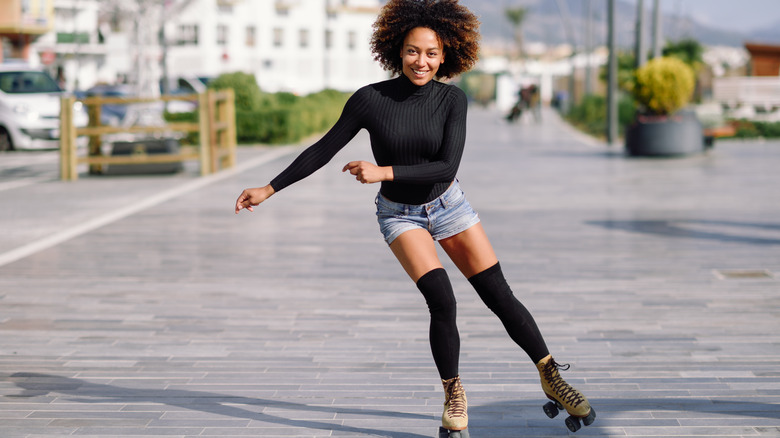 happy woman skating down the streets on a sunny day 